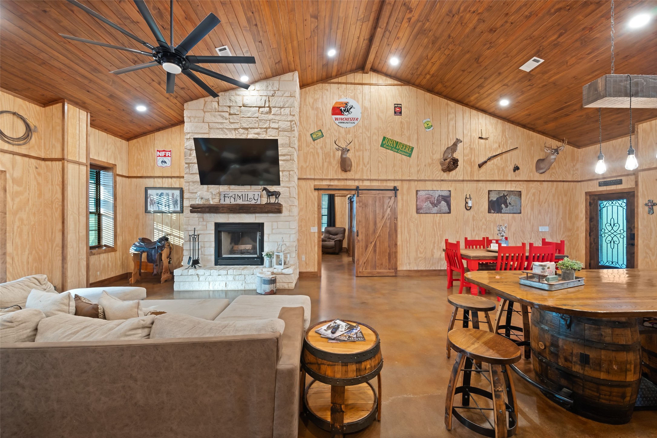 1402 Eagle Ferry Road Anahuac, TX 77514 - Photo 21 of 48 Vaulted wood ceilings, LED lighting, and polished concrete floors frame a gas and wood-burning stone fireplace with a floor-to-ceiling surround.