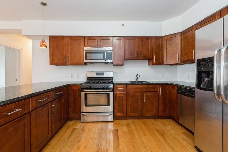 a kitchen with stainless steel appliances granite countertop a refrigerator sink and microwave