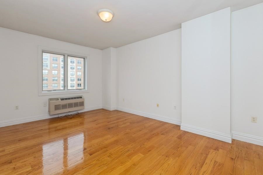 125 43rd Street, Unit 504 Union City, NJ 07087 - Photo 11 of 16 an empty room with wooden floor and windows