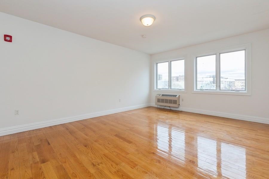 125 43rd Street, Unit 504 Union City, NJ 07087 - Photo 5 of 16 an empty room with wooden floor and windows