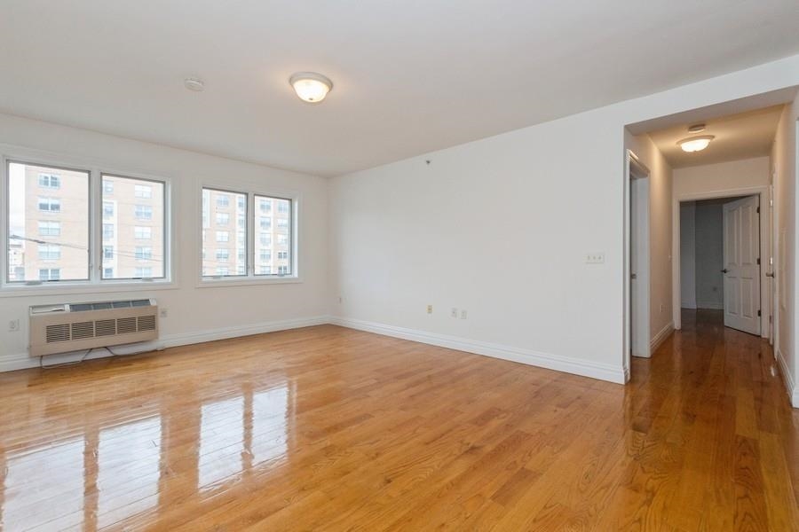 125 43rd Street, Unit 504 Union City, NJ 07087 - Photo 6 of 16 an empty room with wooden floor and windows