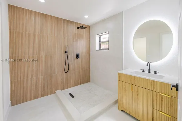 a bathroom with a tub sink and mirror