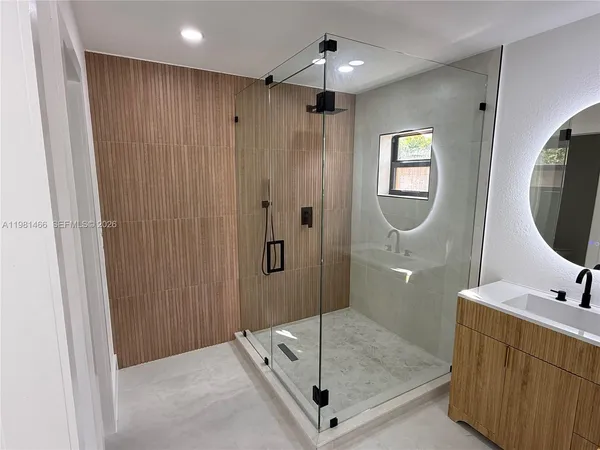 a bathroom with a double vanity sink mirror and shower