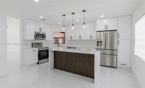 a kitchen with stainless steel appliances granite countertop a refrigerator stove a sink and a oven