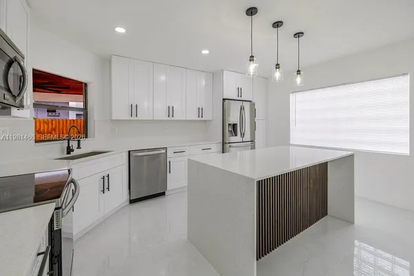 a kitchen that has a lot of cabinets in it and appliances