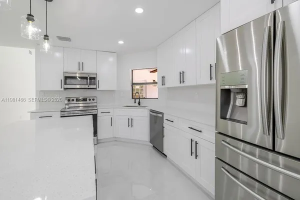 a kitchen with white cabinets and stainless steel appliances