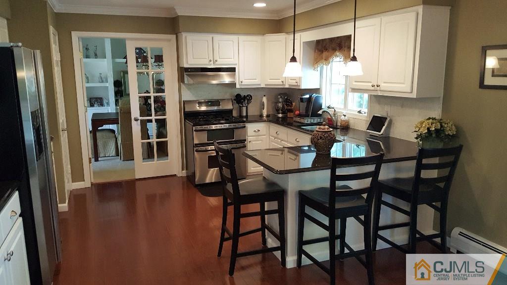53 Higgins Road Old Bridge, NJ 08857 - Photo 6 of 17 a kitchen with stainless steel appliances kitchen island granite countertop a refrigerator a stove a microwave with a dining table and chairs