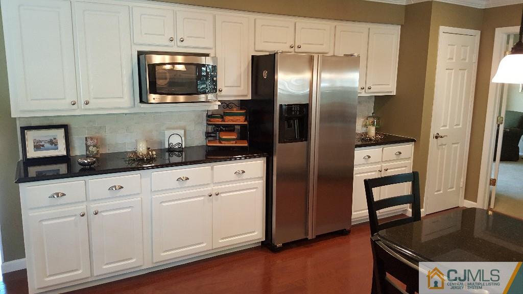 53 Higgins Road Old Bridge, NJ 08857 - Photo 7 of 17 a kitchen with stainless steel appliances granite countertop a refrigerator a stove and a sink with wooden floor