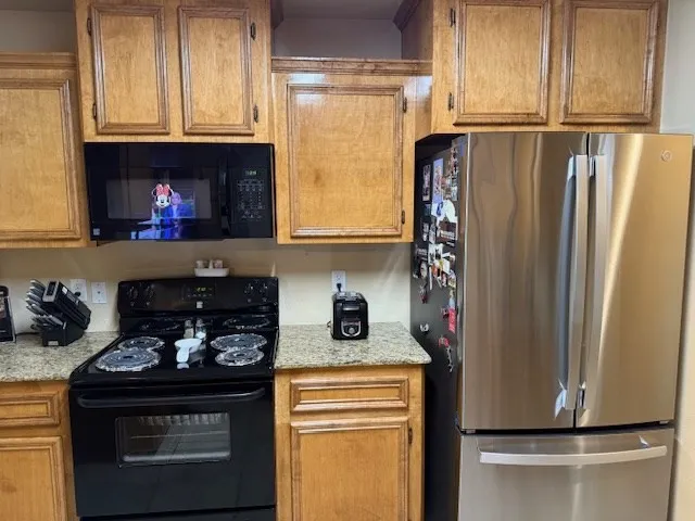 a kitchen with a refrigerator and a stove