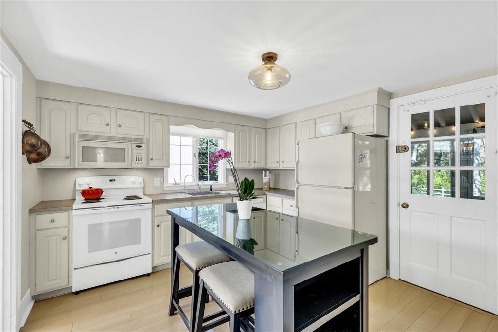 665 Route 6A Sandwich, MA 02537 - Photo 11 of 42 a kitchen with stainless steel appliances a white table chairs and a refrigerator