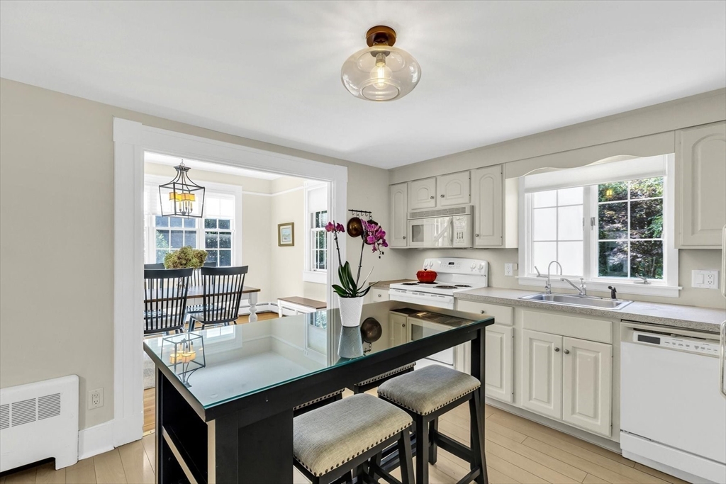 665 Route 6A Sandwich, MA 02537 - Photo 12 of 42 a kitchen with a table chairs stove and cabinets