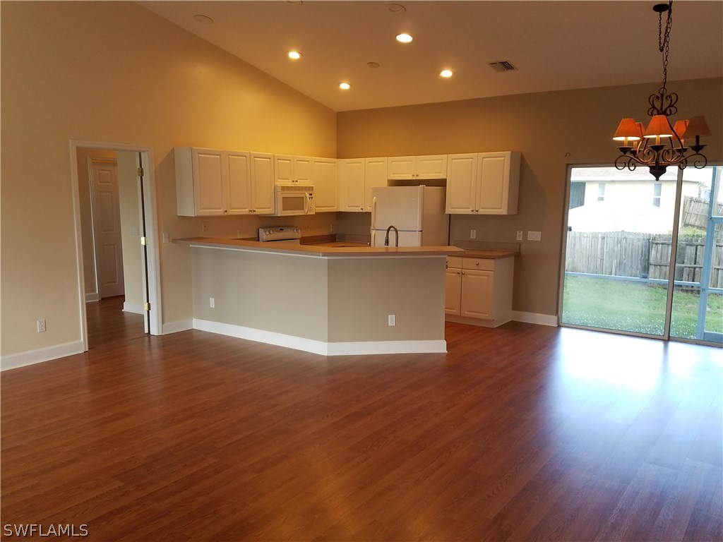 17529 Butler Road Fort Myers, FL 33967 - Photo 4 of 15 a open kitchen with stainless steel appliances granite countertop a refrigerator a sink a stove and oven with wooden floor