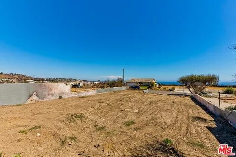 an aerial view of residential building and ocean view in back