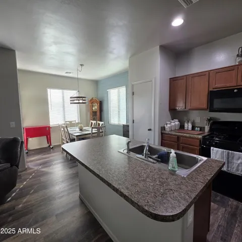 a kitchen with granite countertop a sink a counter top space and cabinets