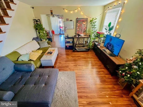 a living room with furniture floor to ceiling window and wooden floor