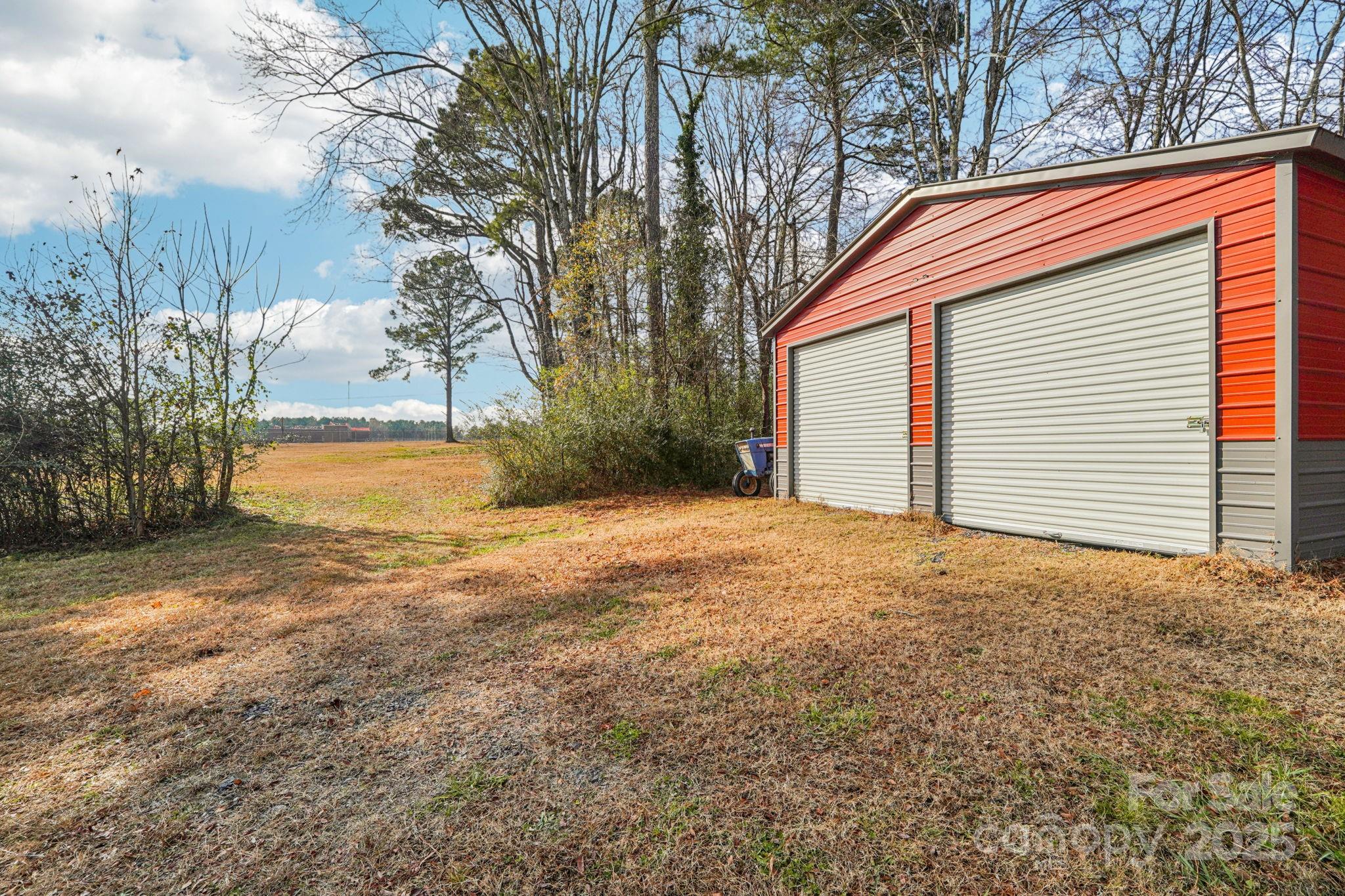 510 Lillys Bridge Road Mount Gilead, NC 27306 - Photo 8 of 18 a backyard of a house with large trees and wooden fence