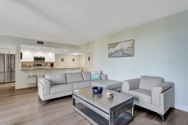a living room with furniture and view of kitchen