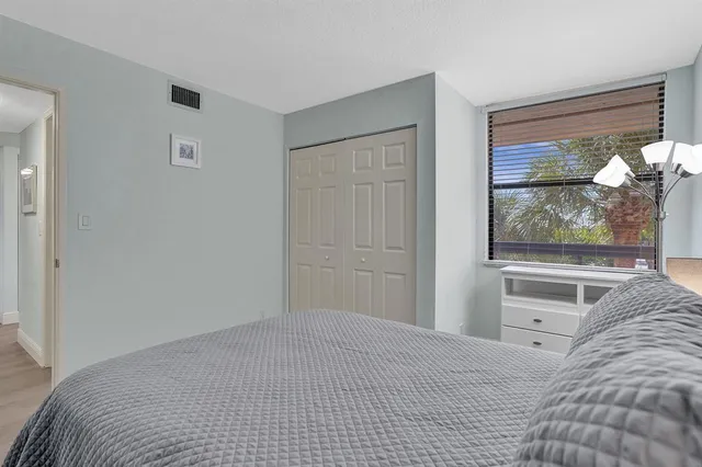 a bedroom with a bed and a large window