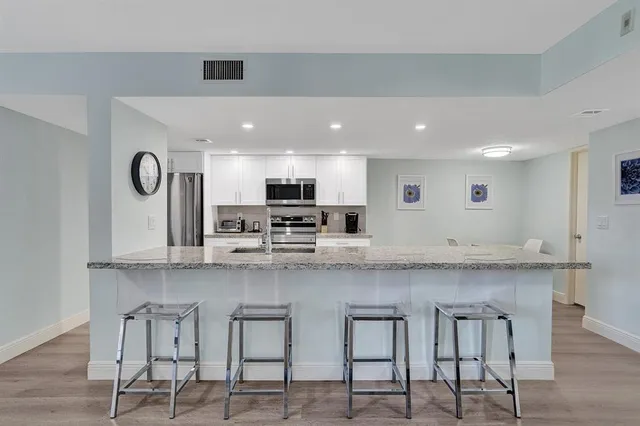 a large white kitchen with lots of counter space and window