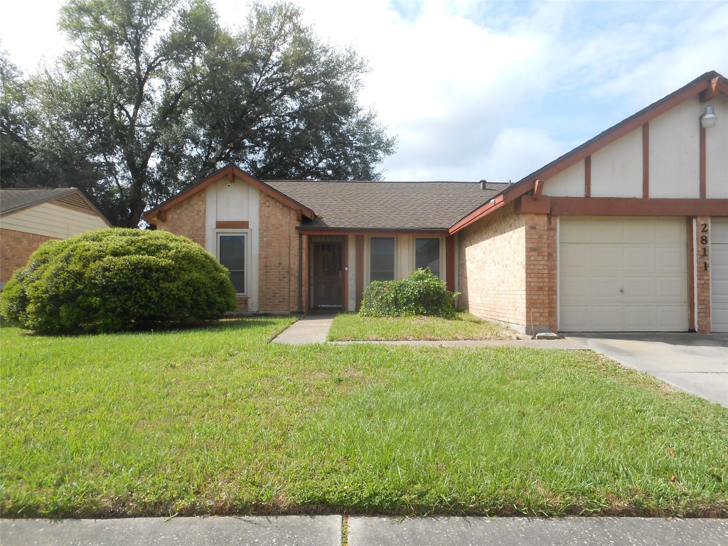 2811 Ashington Drive Houston, TX 77067 - Photo 1 of 9 a front view of a house with a yard and garage