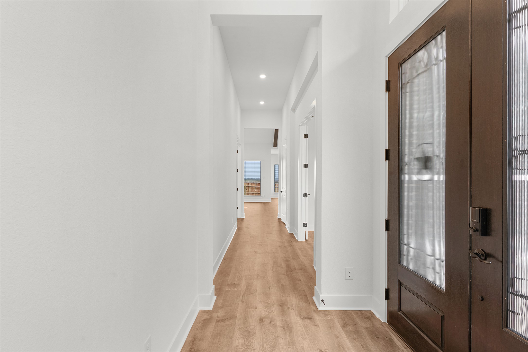 2312 Tobiano Trace Georgetown, TX 78633 - Photo 7 of 33 Entryway featuring a dark wood door with patterned glass, recessed lighting, white baseboards, and wood-finish flooring