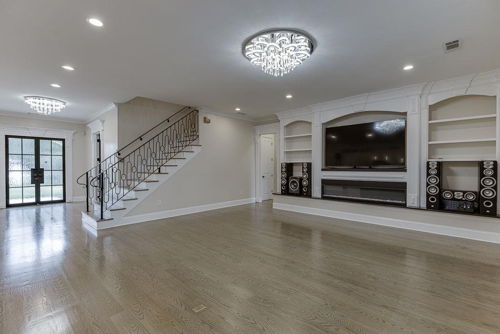 861 Bailey Woods Road Dacula, GA 30019 - Photo 12 of 67 an empty room with wooden floor chandelier entryway and windows