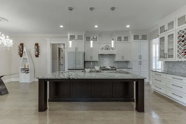 a kitchen with granite countertop stainless steel appliances and white cabinets