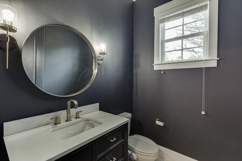 861 Bailey Woods Road Dacula, GA 30019 - Photo 31 of 67 a bathroom with a toilet a sink a mirror and a window