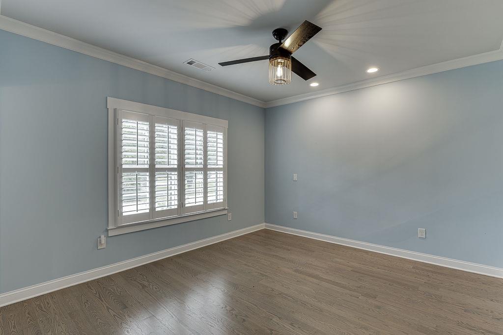 861 Bailey Woods Road Dacula, GA 30019 - Photo 38 of 67 an empty room with wooden floor ceiling fan and windows