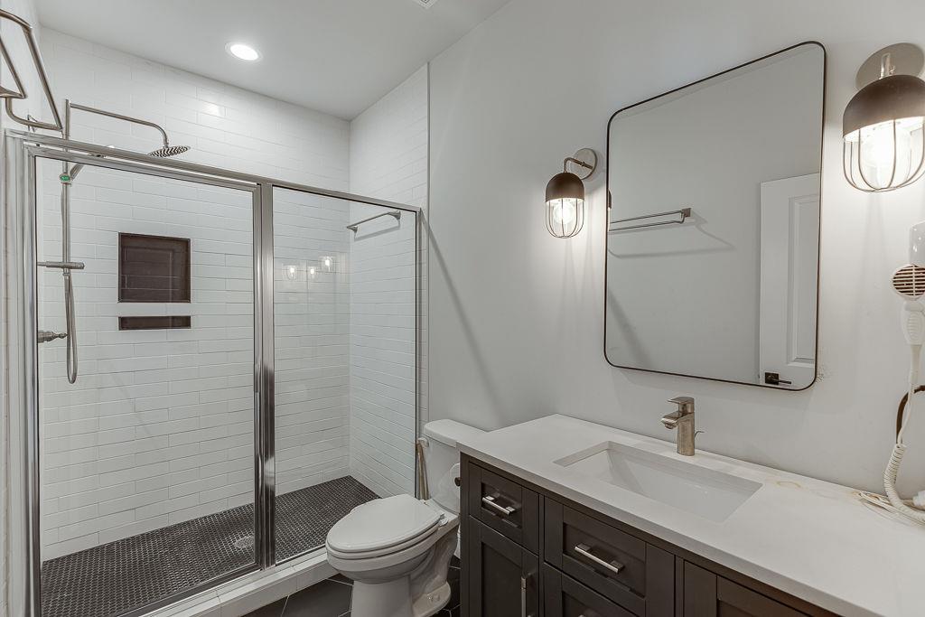 861 Bailey Woods Road Dacula, GA 30019 - Photo 46 of 67 a bathroom with a granite countertop sink toilet and shower