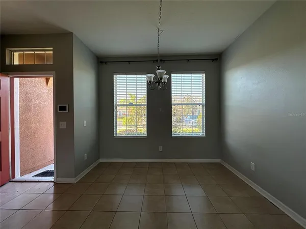 a view of a livingroom with a chandelier fan and windows