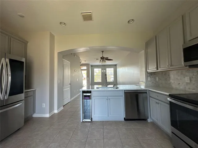 an empty room with windows and fan