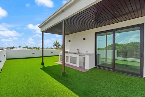 a front view of a house with a yard and potted plants