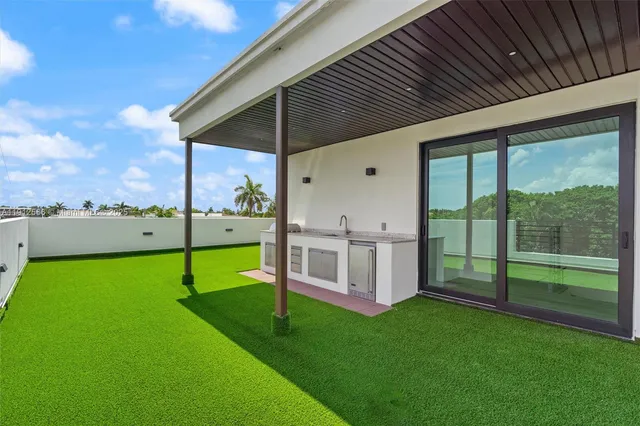 a front view of a house with a yard and potted plants