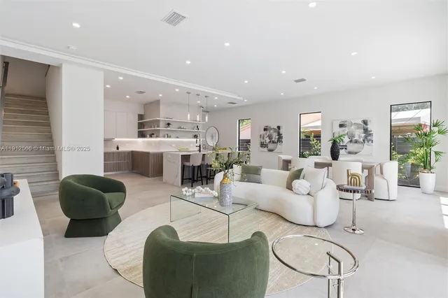 a living room with furniture and view of kitchen