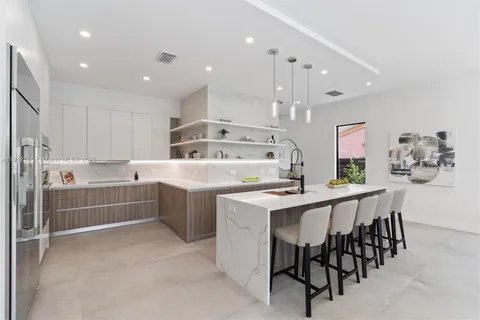 a kitchen with a table chairs sink and cabinets