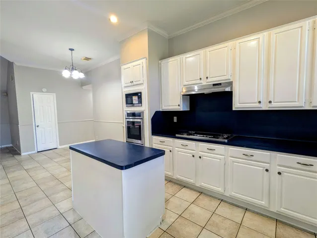 a kitchen with granite countertop a sink a stove and cabinets