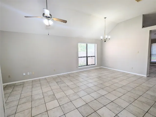 an empty room with windows and ceiling fan