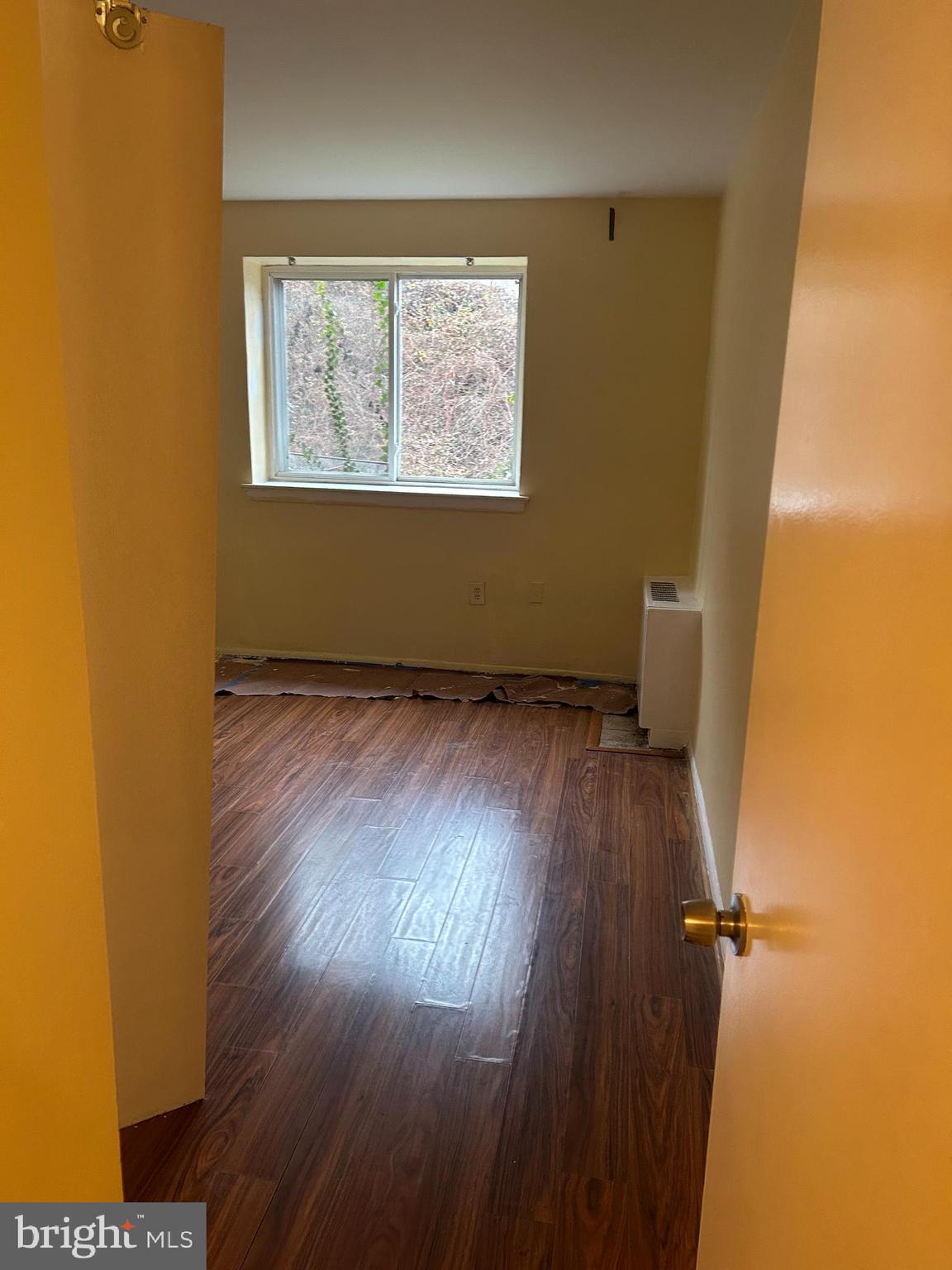 9250 Edwards Way, Unit 103A Hyattsville, MD 20783 - Photo 6 of 8 an empty room with wooden floor and windows