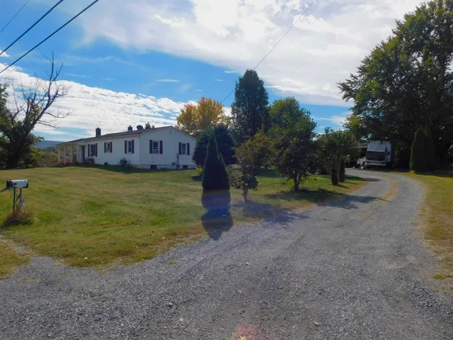 a view of a house with a yard and sitting area