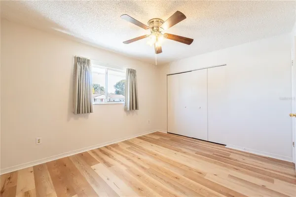 a view of a big room with wooden floor and a ceiling fan