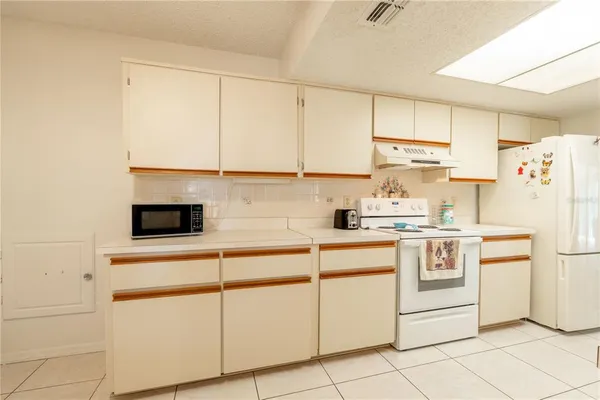 a kitchen with white cabinets and white appliances