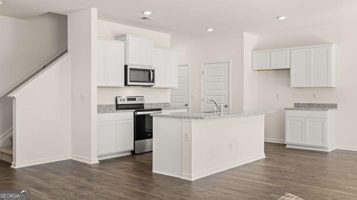 11929 Aukerman Way Hampton, GA 30228 - Photo 4 of 13 a kitchen with kitchen island white cabinets and stainless steel appliances