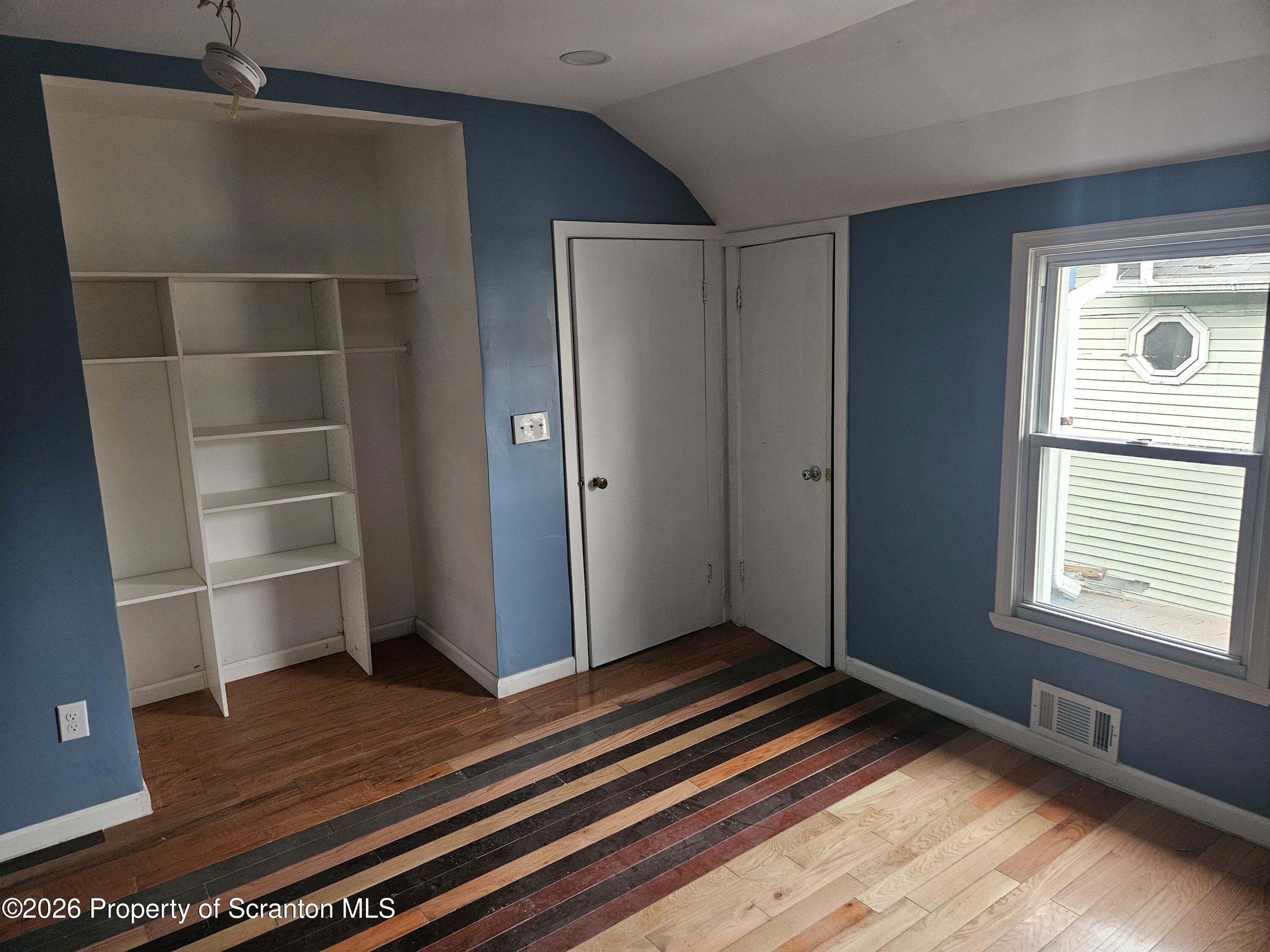 335 Phelps Street, Unit 2 REAR Scranton, PA 18509 - Photo 8 of 13 a view of an empty room with wooden floor and a window