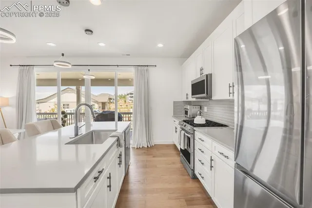 a large kitchen with stainless steel appliances granite countertop a lot of counter space and a sink