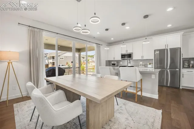 a view of kitchen with refrigerator table and chairs