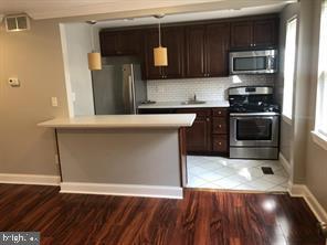a kitchen with granite countertop a stove and a microwave