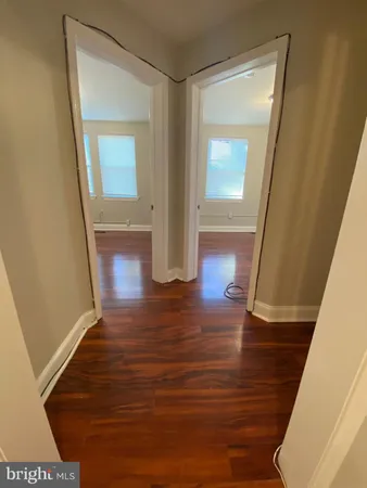 a view of a hallway with wooden floor