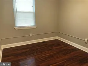 a view of a small space with wooden floor and a window