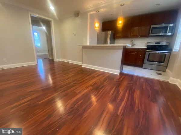 a kitchen with stainless steel appliances wooden floors and granite counter tops